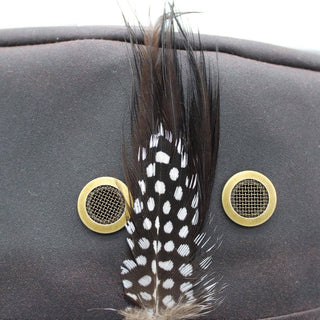 Feather decoration  on hat with gold circular elements on a dark background - Pangolins