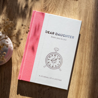 Book titled 'Dear Daughter from you to me' on a wooden surface with a pink cover - Pangolins