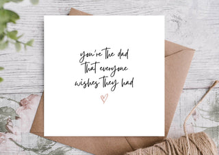 Greeting card with 'you're the dad that everyone wishes they had' text on a wooden surface - Pangolins