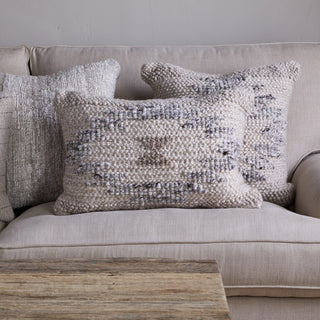Nkuku Tendai wool and cotton cushion cover styled on a neutral sofa with layered cushions