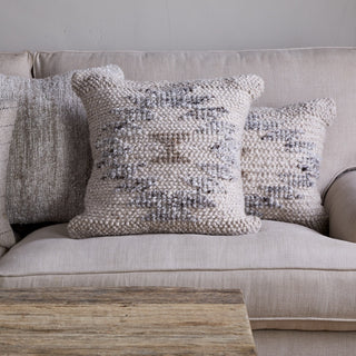 Nkuku Tendai wool and cotton cushion cover styled on neutral sofa with layered cushions