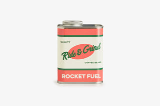 Coffee bean tin labeled 'Ride & Grind Rocket Fuel' on a white background