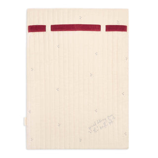 A cream-colored quilted Christmas sack with a vertical channel-stitch pattern, decorated with a red ribbon across the top and small gray embroidered stars. The bottom right corner features the cursive text 'sweet time this weekend.