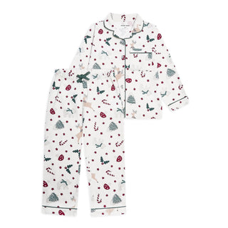 Avery Row two-piece children's pyjama set featuring a white long-sleeve top and matching pants with a festive Christmas print of trees, candy canes, snow globes, and holly, finished with dark green piping.