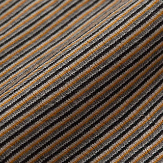 A close-up of a woven fabric with diagonal stripes in black, gray, white, and mustard yellow.